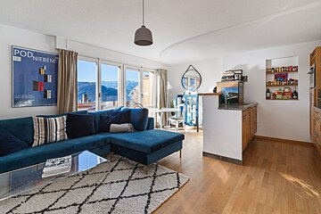 A living room with a blue couch and a poster that says pod niebem