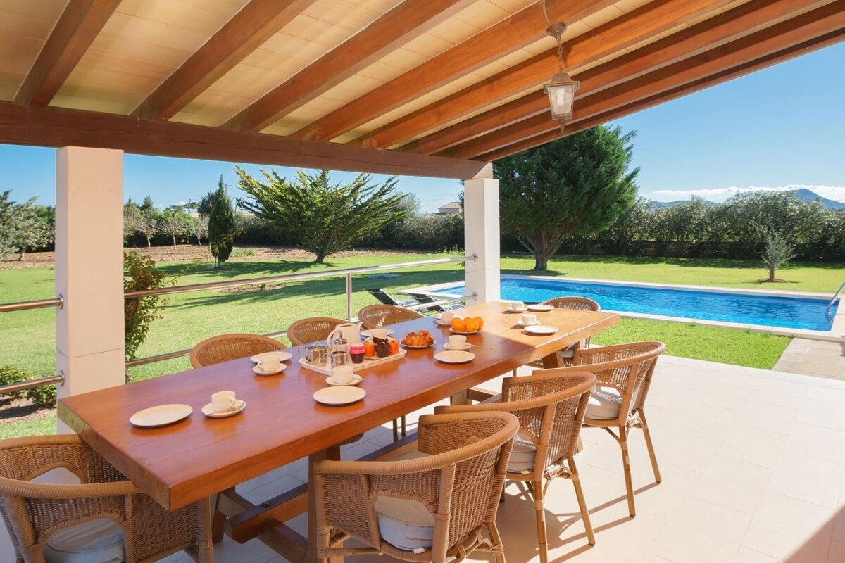 A white house with a large swimming pool in front of it