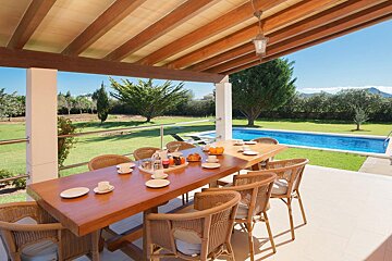 A white house with a large swimming pool in front of it