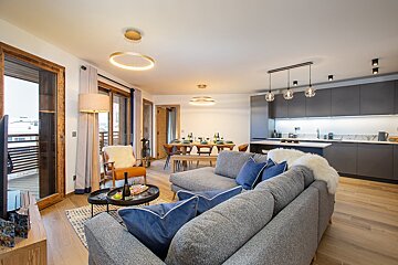 A living room with a grey couch and blue pillows