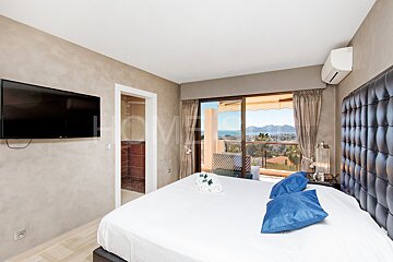 A bedroom with a large bed and a flat screen tv