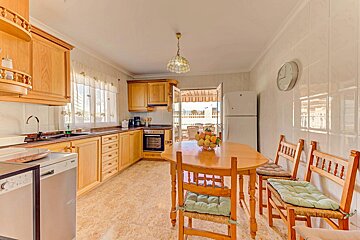 A kitchen with a table and chairs and a clock on the wall