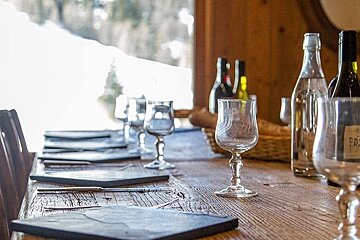 A wooden table with wine glasses and bottles on it