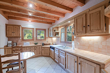 A kitchen with wooden cabinets and a wooden ceiling