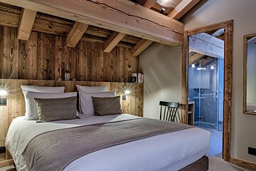 A bedroom with a king size bed and wooden walls
