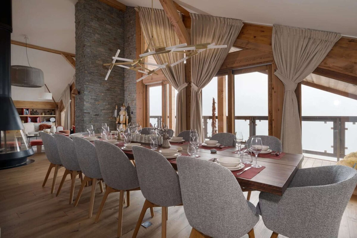 A dining room with a long table and chairs