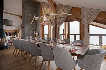 A dining room with a long table and chairs