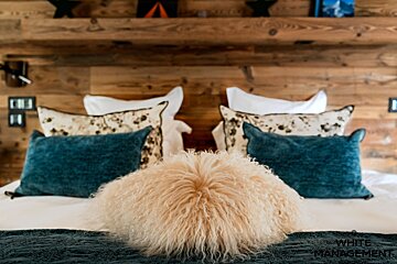 A bed with a rental designer logo in the corner