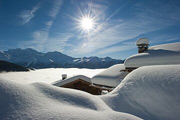 The sun is shining brightly over the snowy mountains
