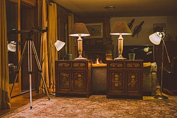 A living room with two lamps and a cabinet with chinese writing on it
