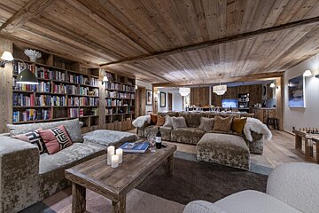 A living room with a couch and a table with a bottle of wine on it