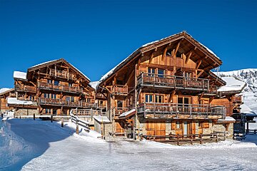 A large wooden building with a blue sky in the background