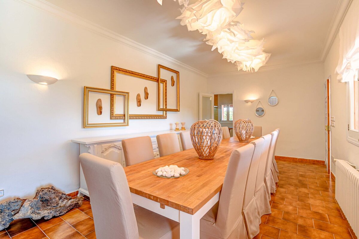 A dining room with a long wooden table and chairs