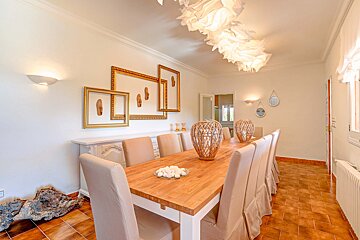 A dining room with a long wooden table and chairs