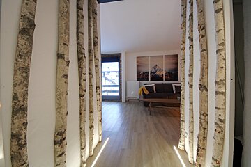 A living room with a couch and paintings on the wall