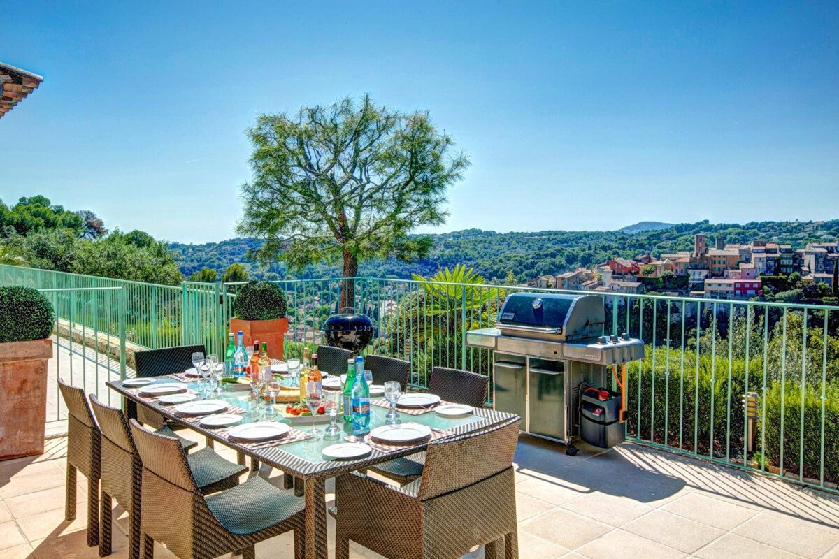 A patio with a table and chairs and a grill