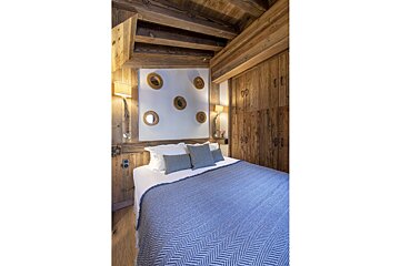 A bedroom with a bed and mirrors on the wall