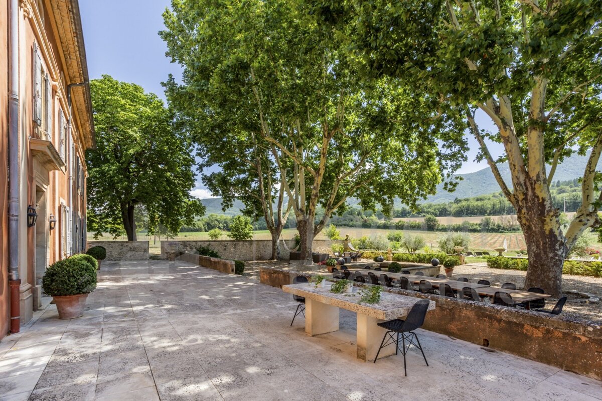 A patio with a table and chairs under trees