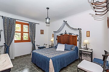 A bedroom with a canopy bed and two lamps