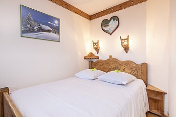 A bedroom with a bed and a picture on the wall