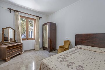 A bedroom with a bed dresser and mirror