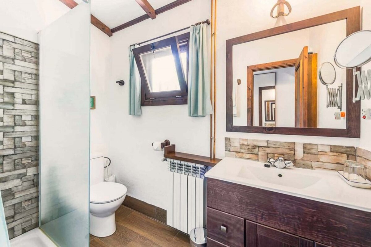 A bathroom with a toilet a sink and a mirror