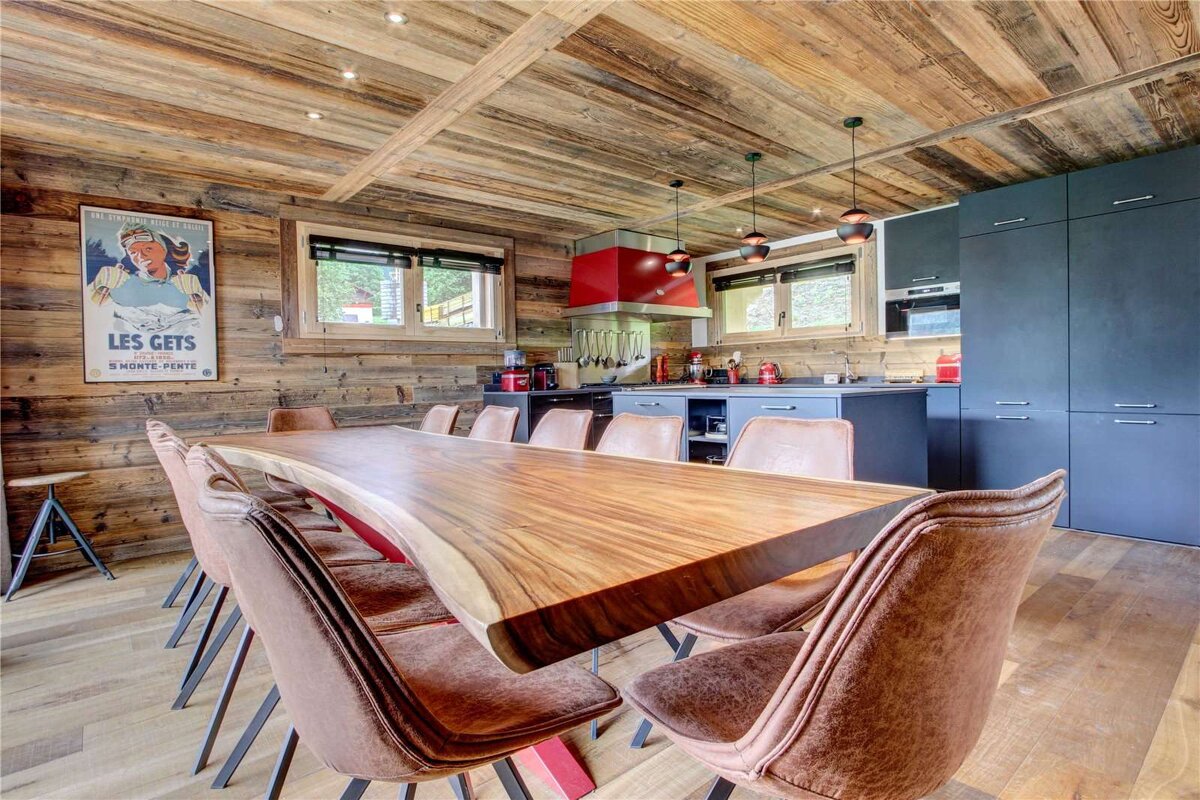 A kitchen with a table and chairs and a poster that says les gets