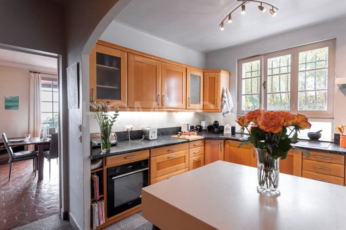 A kitchen with a vase of flowers on the counter