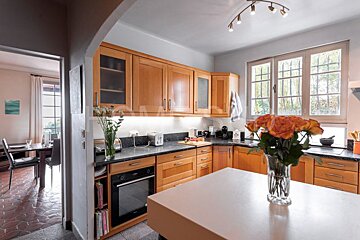 A kitchen with a vase of flowers on the counter