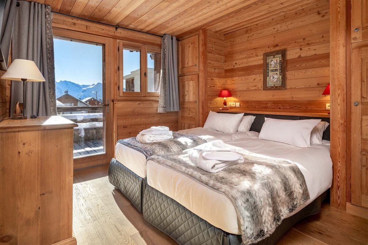 A bedroom with two beds and a painting on the wall