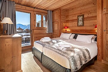 A bedroom with two beds and a painting on the wall