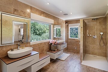 A bathroom with two sinks and a walk in shower