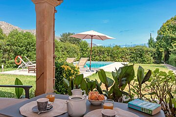A table with a bowl of oranges and a book on it