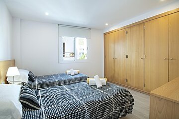 A bedroom with two beds and a window