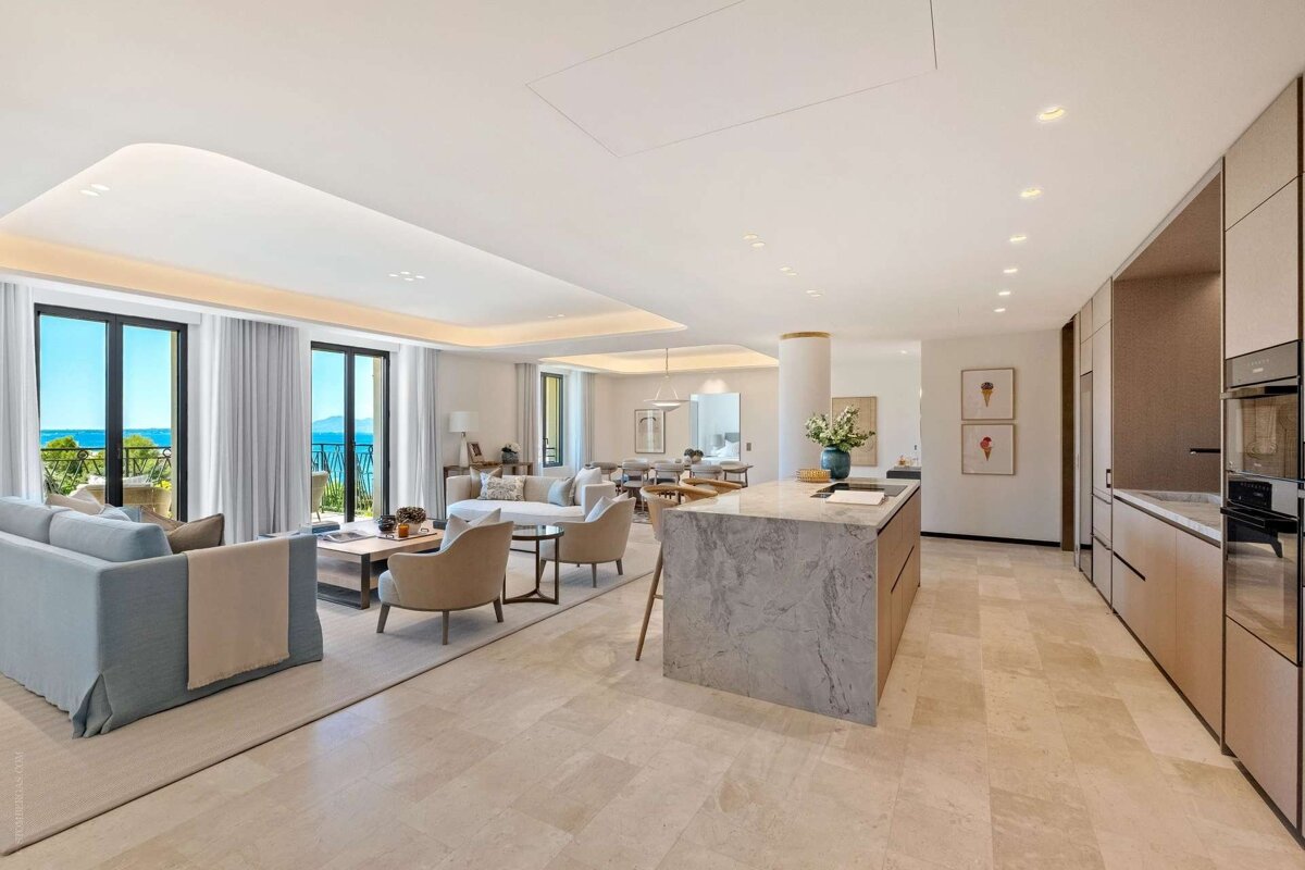Luxurious open-concept room with a marble kitchen island, elegant living and dining areas, and a stunning sea-view balcony.