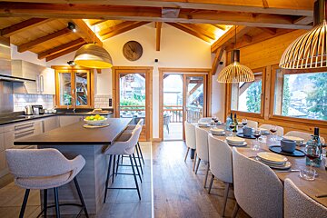 A kitchen and dining area with a clock on the wall