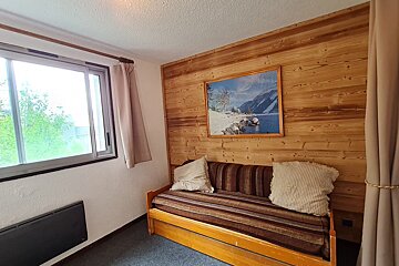 A room with a couch and a picture on the wall