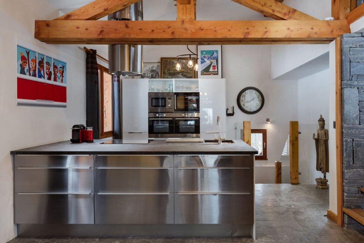 A kitchen with stainless steel cabinets and a clock on the wall