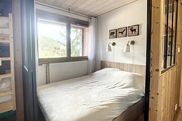 A bedroom with a bed and three pictures on the wall