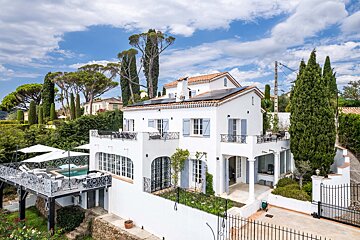 A large white house with solar panels on the roof