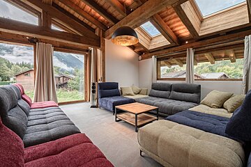 A living room with a lot of couches and a skylight