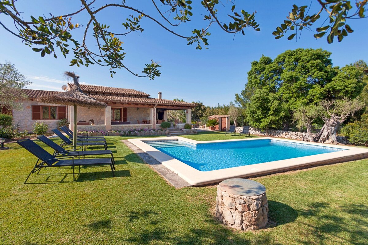 A house with a large swimming pool in front of it