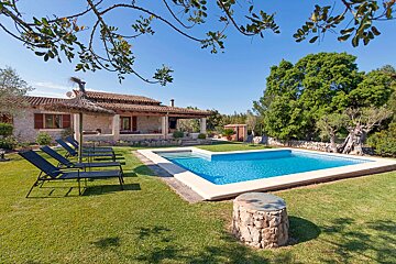 A house with a large swimming pool in front of it