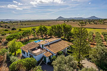 An aerial view of a house with a pool and mountains in the background