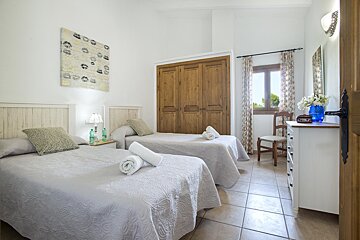 A bedroom with two twin beds and a dresser