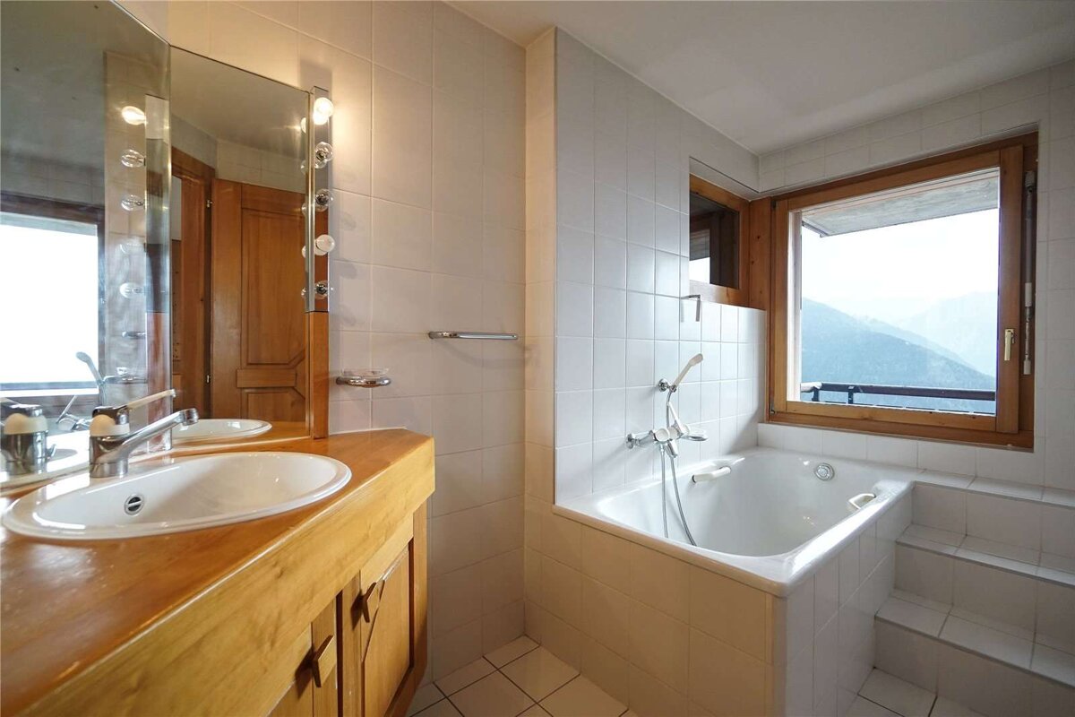 A bathroom with two sinks and a bathtub