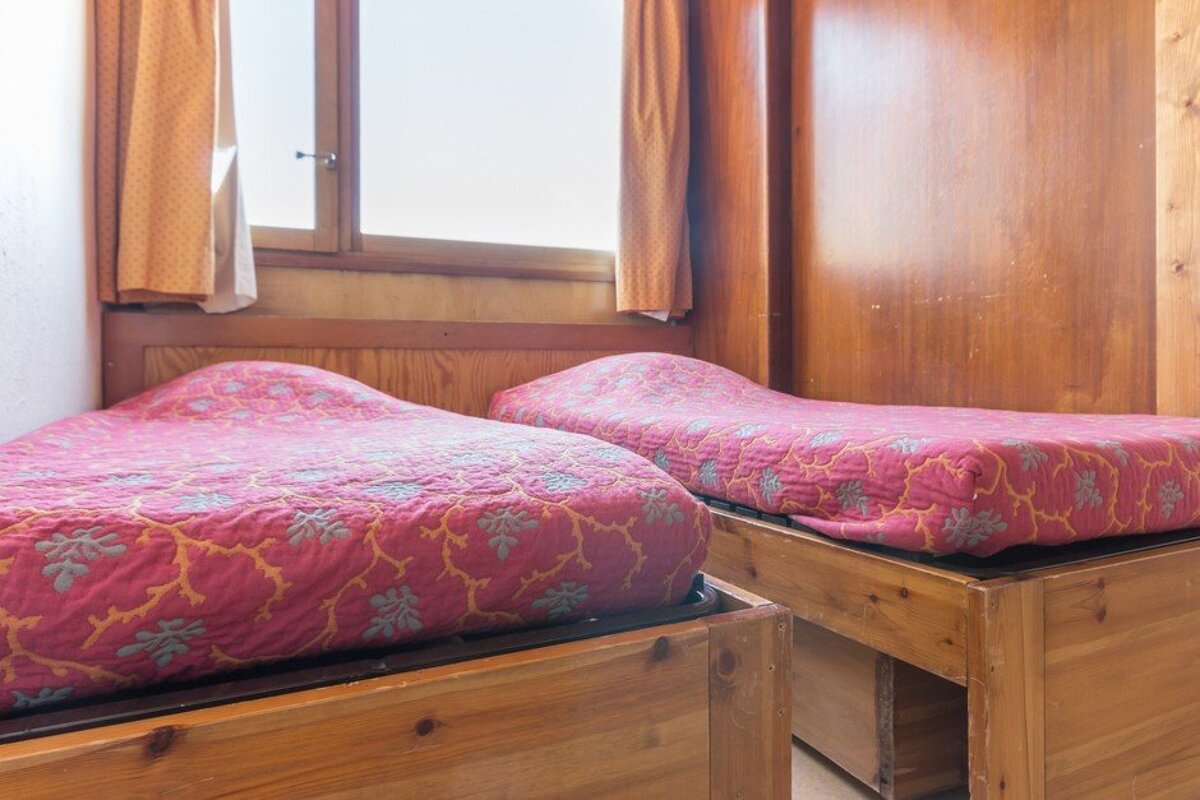 A bedroom with two beds and a window