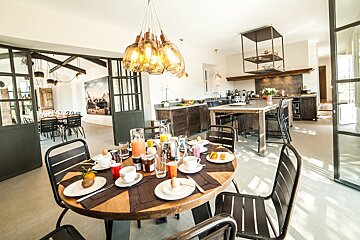 A dining room table with plates of food and drinks on it