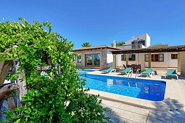 A house with a large swimming pool in front of it