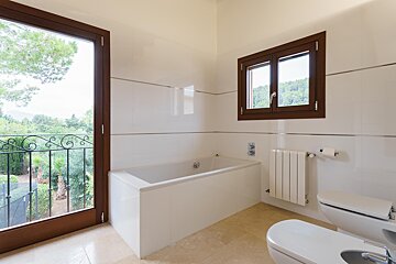 A bathroom with a bathtub toilet and window